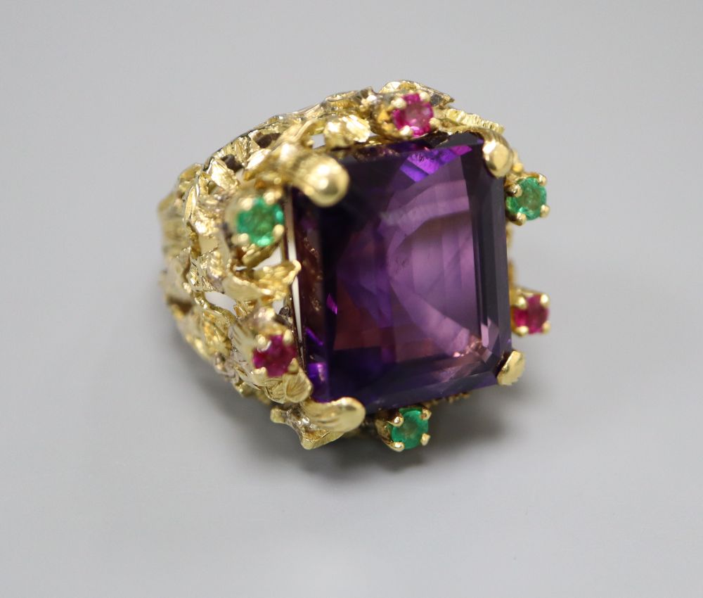 A yellow metal, amethyst, emerald and ruby cluster set naturalistic dress ring, size M, gross 20.9 grams.